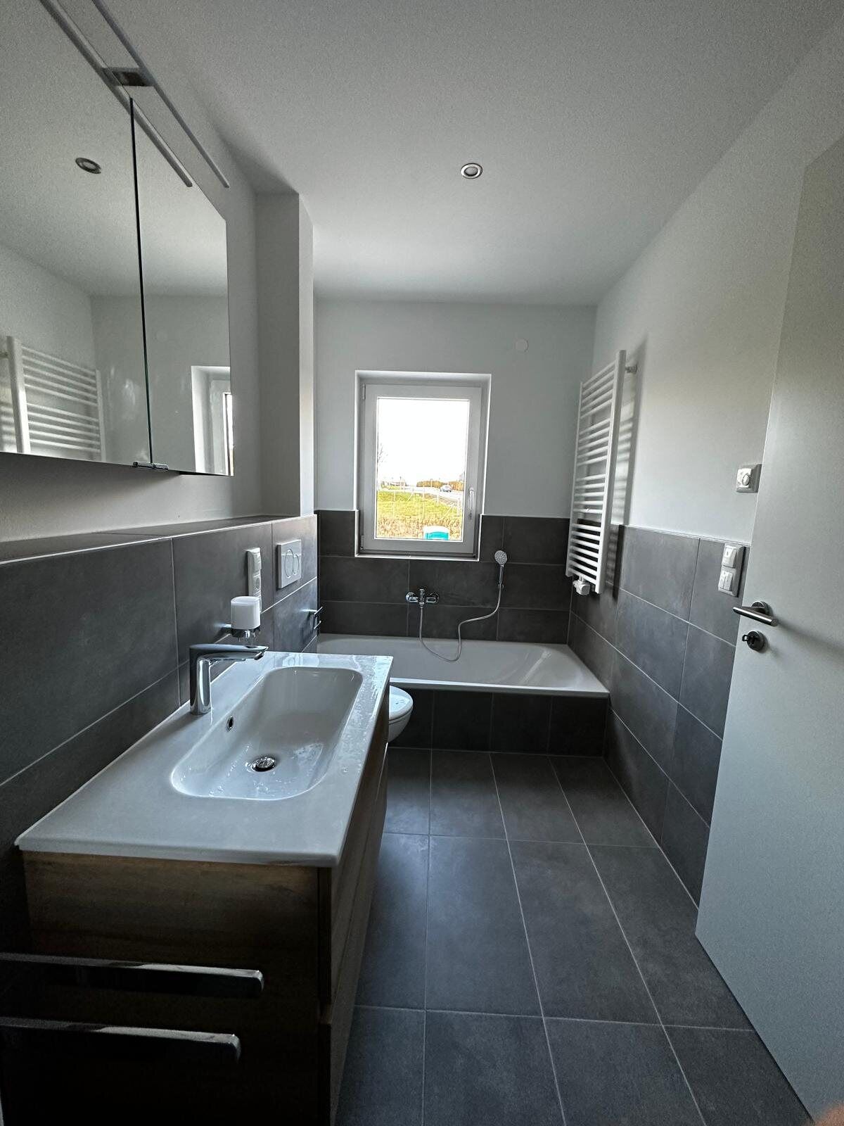 Badezimmer mit Badewanne und Waschtisch im Projekt Wohnen am Hammerberg