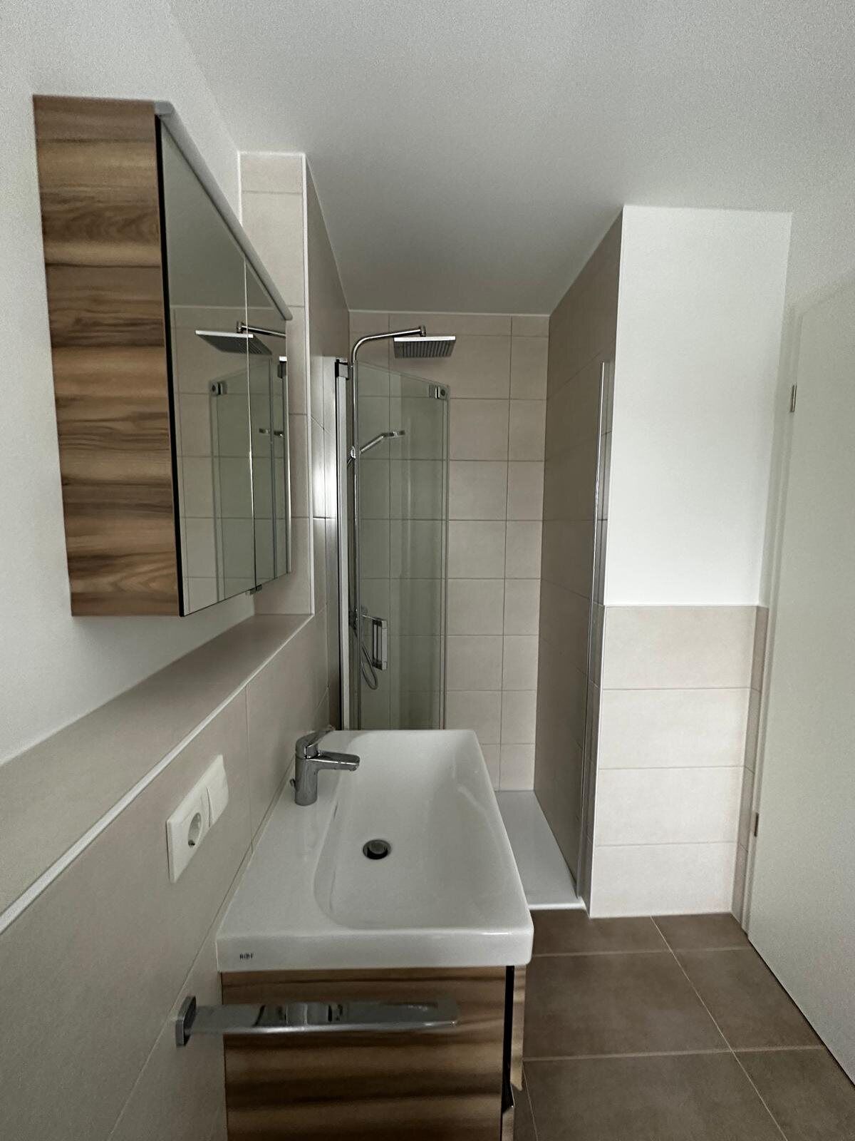Helles Badezimmer mit Dusche und Waschtisch am Hammerberg